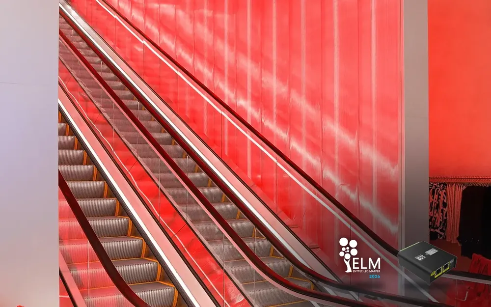 The escalator at the Times Square flagship climbing beside a tall ribbed wall backlit in deep red