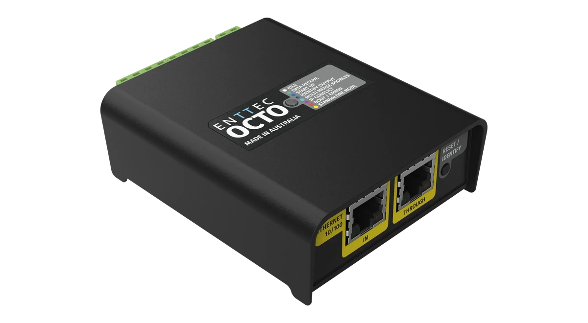 The OCTO from above at an angle, its lid printed 'ENTTEC OCTO, MADE IN AUSTRALIA' beside the grey LED legend, with the yellow ETHERNET 10/100 IN and THROUGH RJ45 sockets and the RESET / IDENTIFY button on the near face and green screw terminals along the far edge.