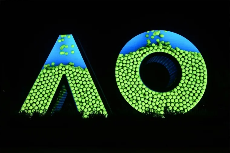 The letter faces massed with green ball graphics against a black night sky, a strip of blue along the top edge