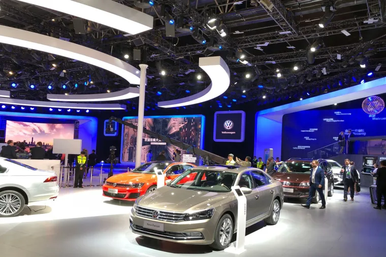 Champagne Passat in the foreground with an orange hatchback and further cars lined up along the blue-lit back wall