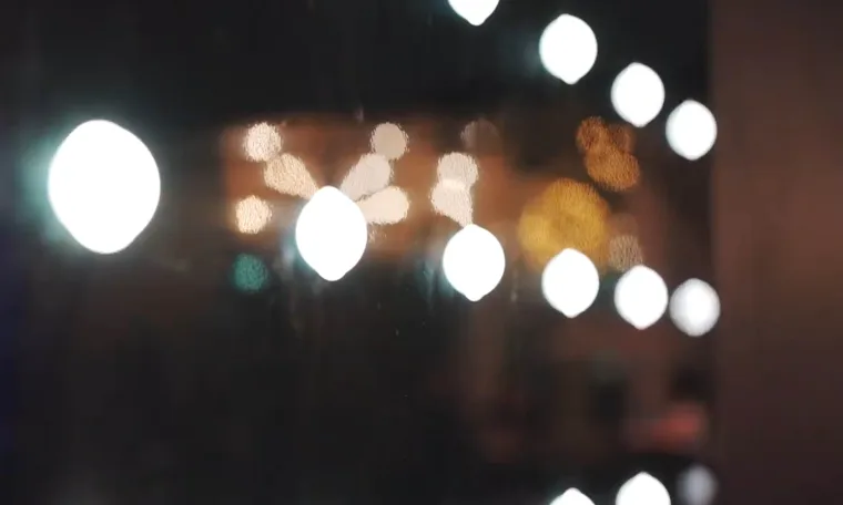 Pixel dots thrown out of focus, white and amber circles floating across a dark background