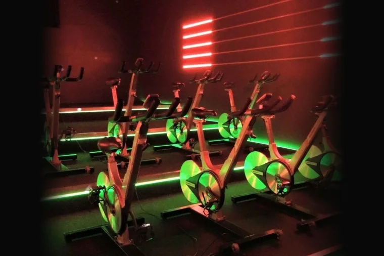 The empty studio before a class, bikes ranked in rows and the wall strips glowing red and green