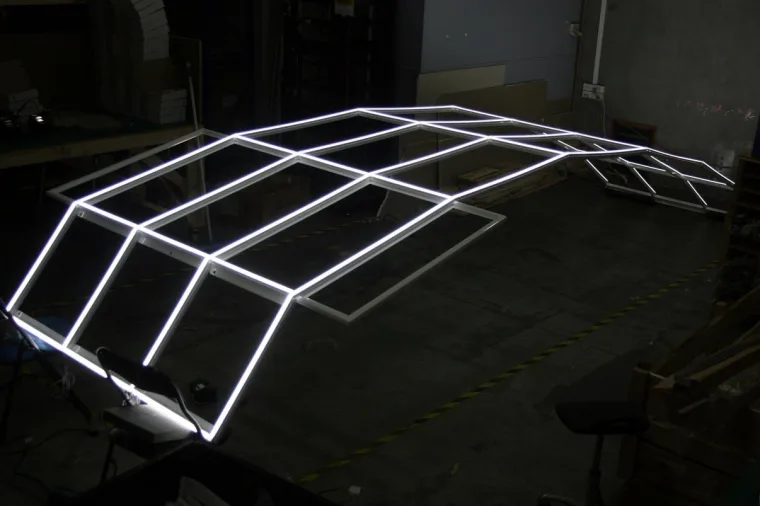 The same frame in the workshop from the side, the curve of the structure clear where it lifts off the concrete