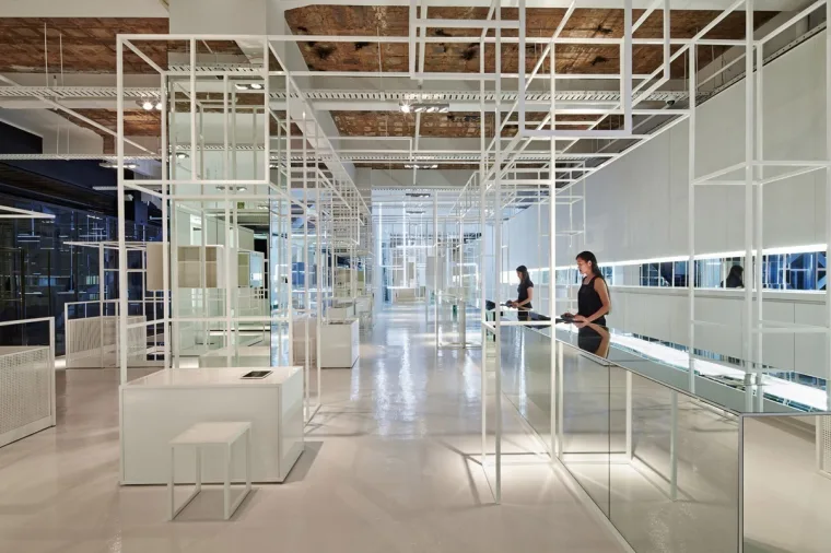 The same aisle from a step back, mirrored chambers on the left doubling the white grid away into the distance
