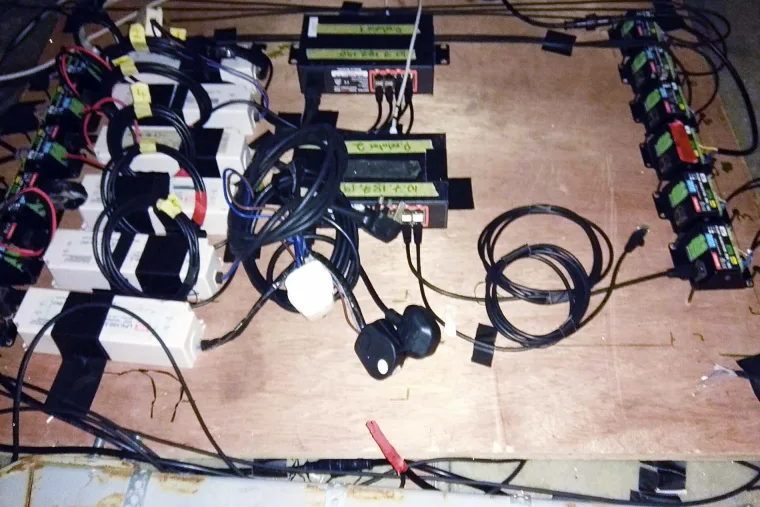 Overhead view of the control gear laid out on plywood, labelled power supplies and injectors with cable runs taped down between them