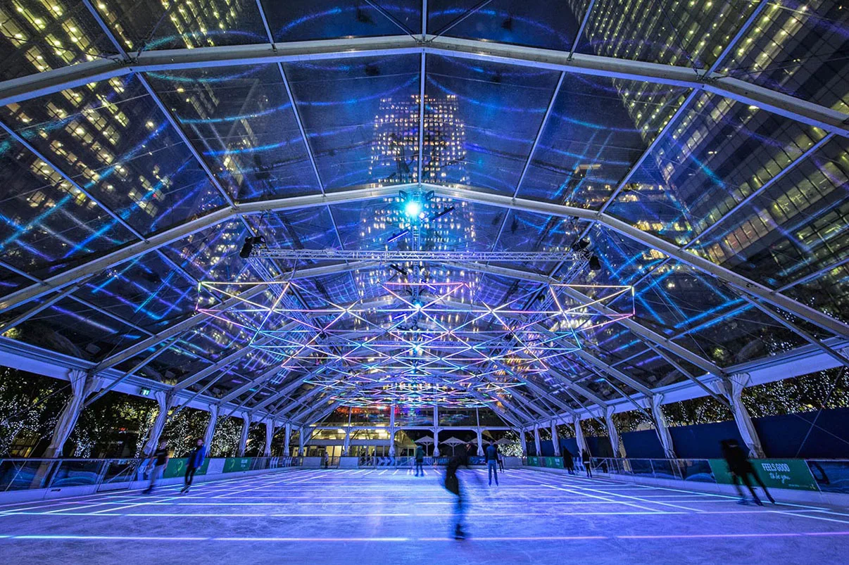 Looking down the length of the canopy, a mirror ball high in the roof and a faint white grid on quiet ice