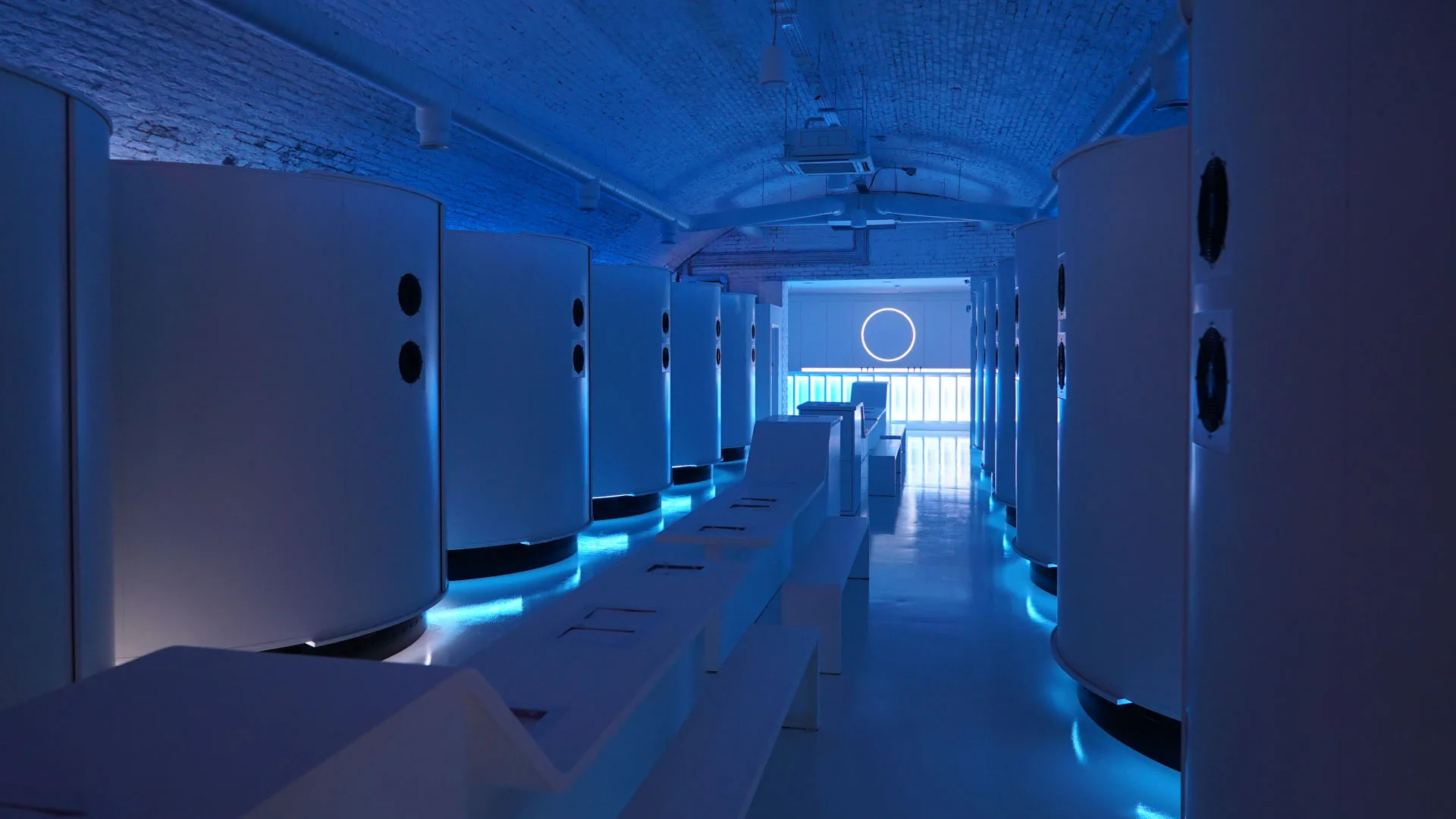 The arch from the far end in deep blue, pod doors on both sides and the neon ring floating above the entrance