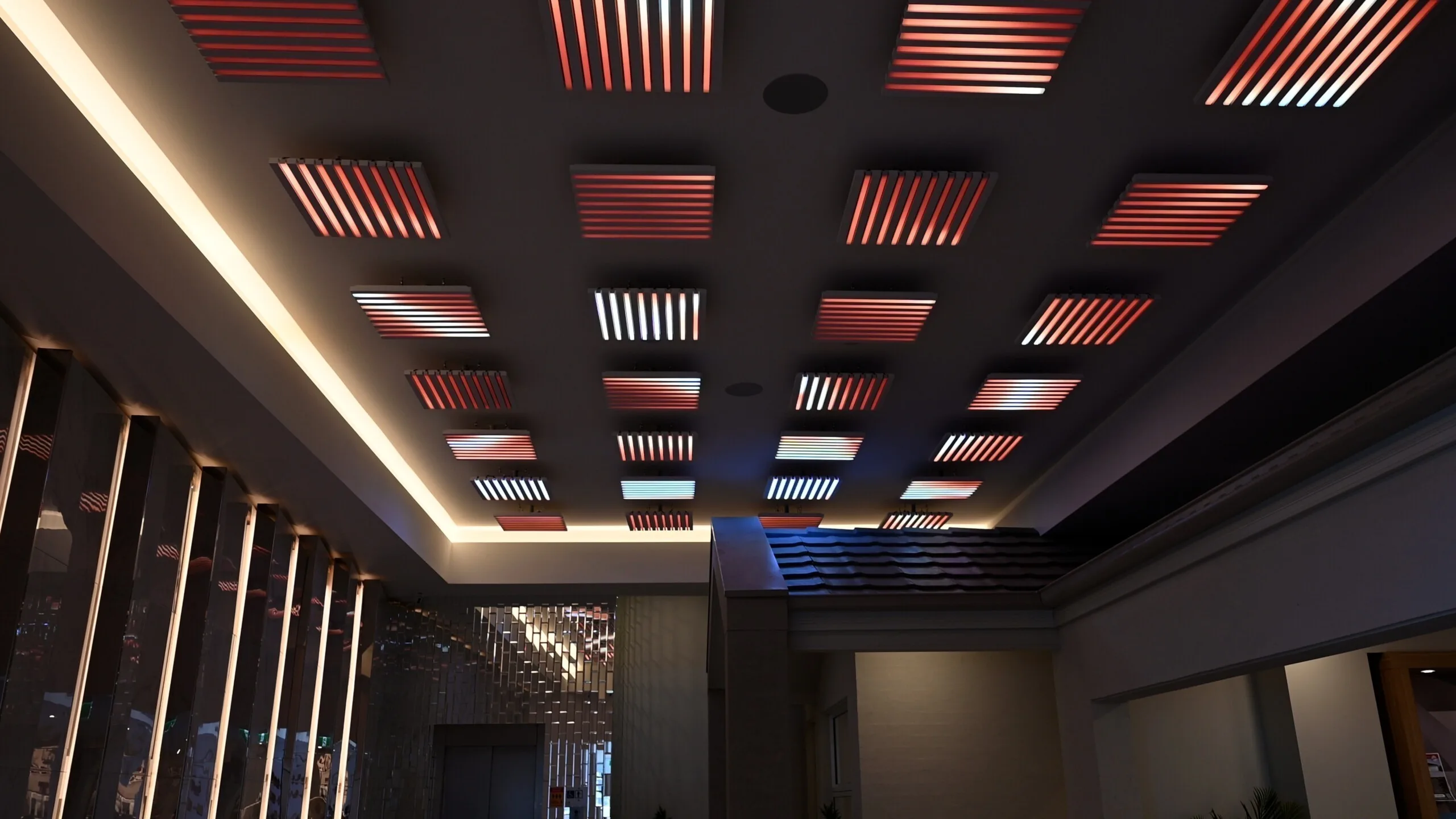 Looking up at the dark ceiling, pods striped red, white and blue with warm cove lighting around the edge