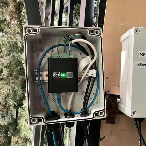 An ENTTEC OCTO mounted inside a weatherproof enclosure on the tree frame, blue data leads and white power cable running out of the glands