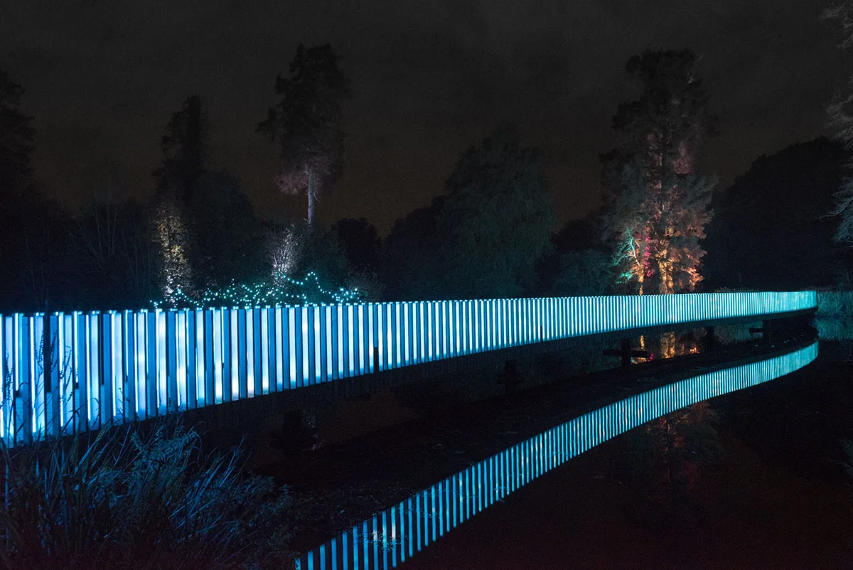The balustrade running cyan and white, a crisp mirror image of the uprights on the water below
