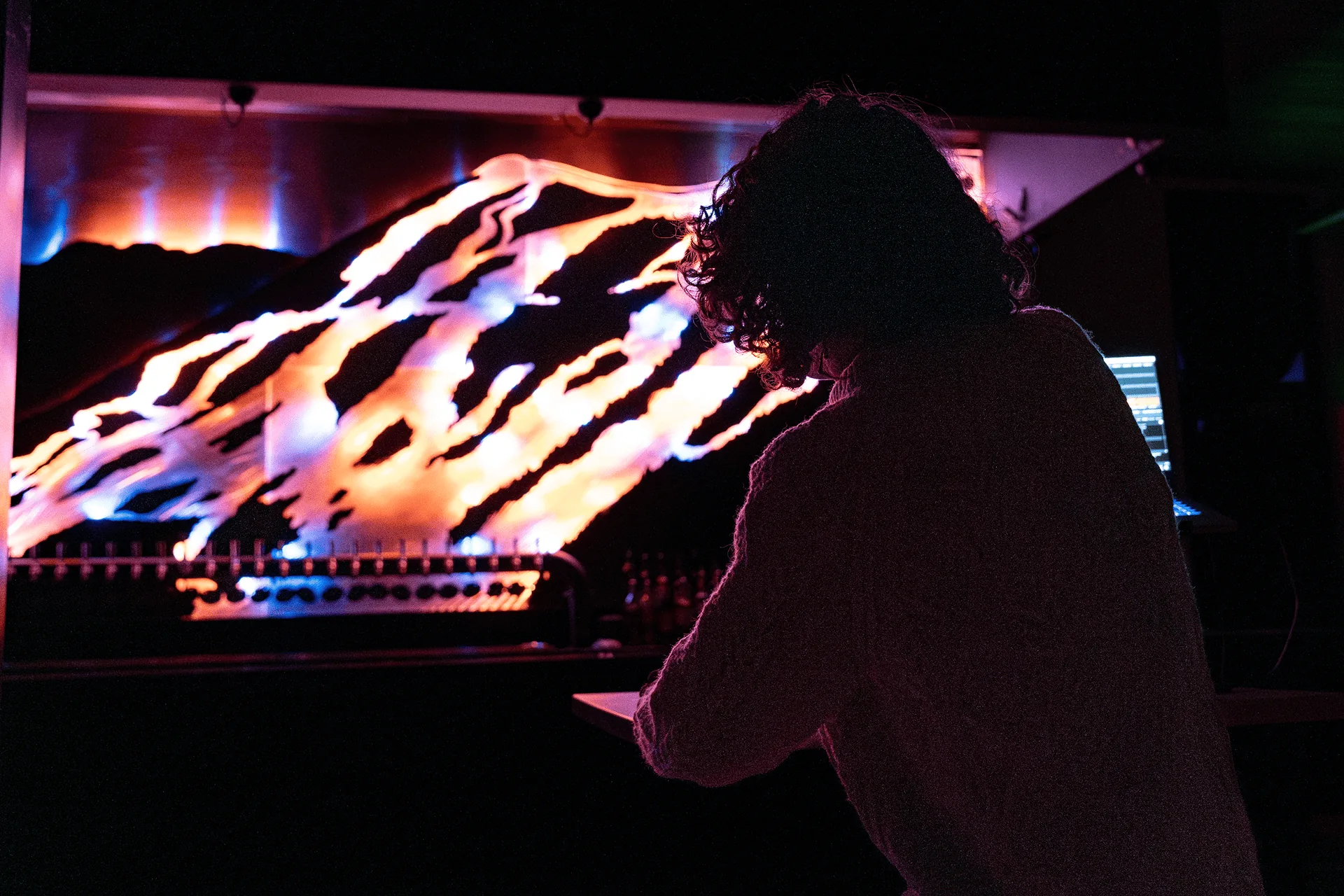 Live control from a controller at the bar, the sculpture lit blue and pink behind