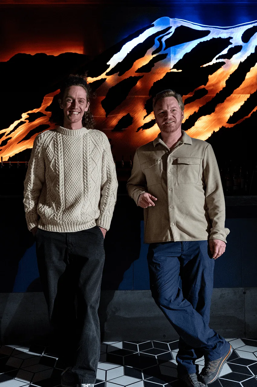 The two artists standing in front of the finished, lit installation