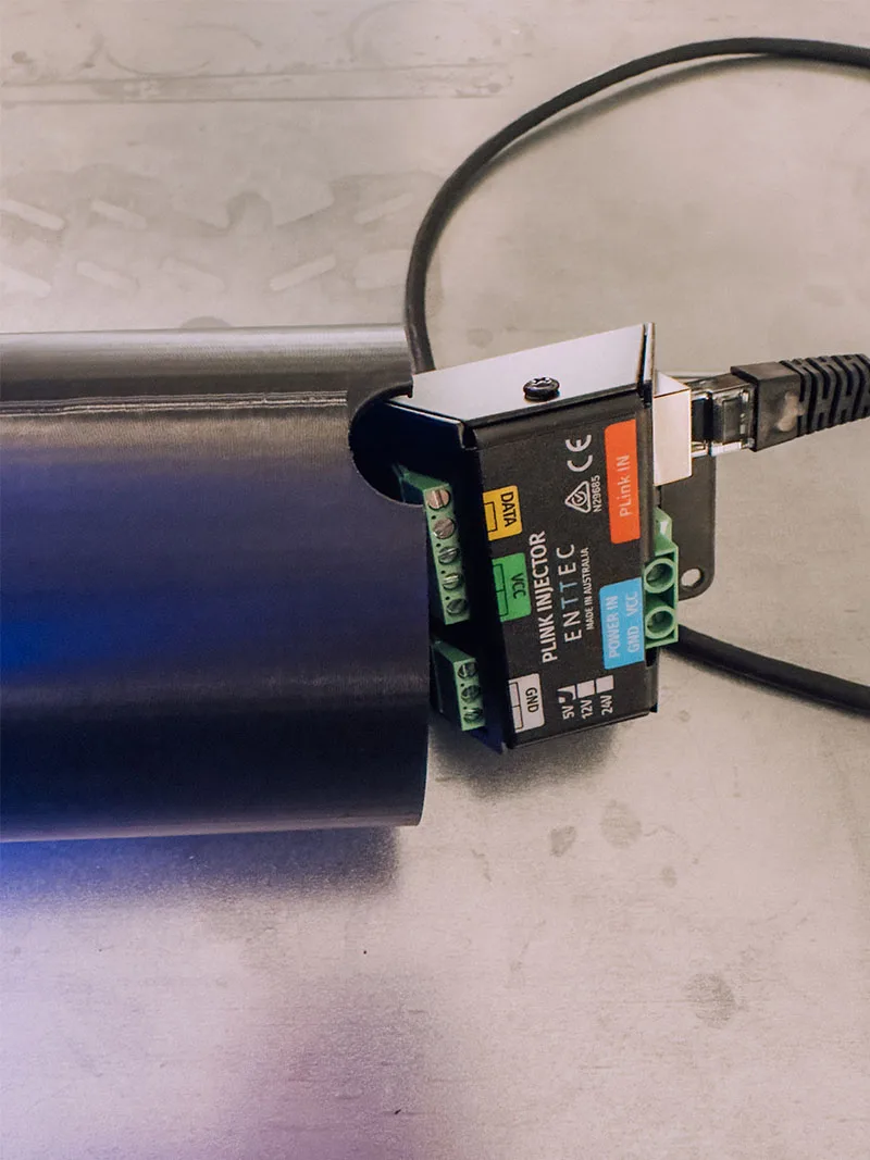 Close up of a PLink injector clipped to the top of a canopy, a network cable plugged into its socket