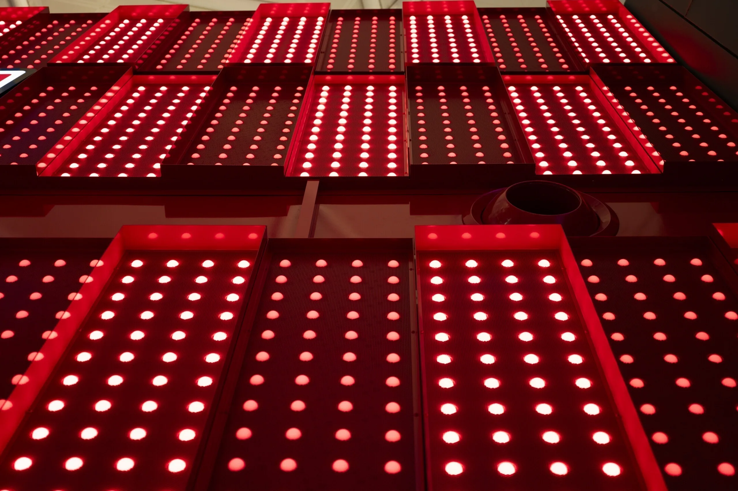 Overlapping rows of angled panels seen from directly beneath, dark gaps running between each red section