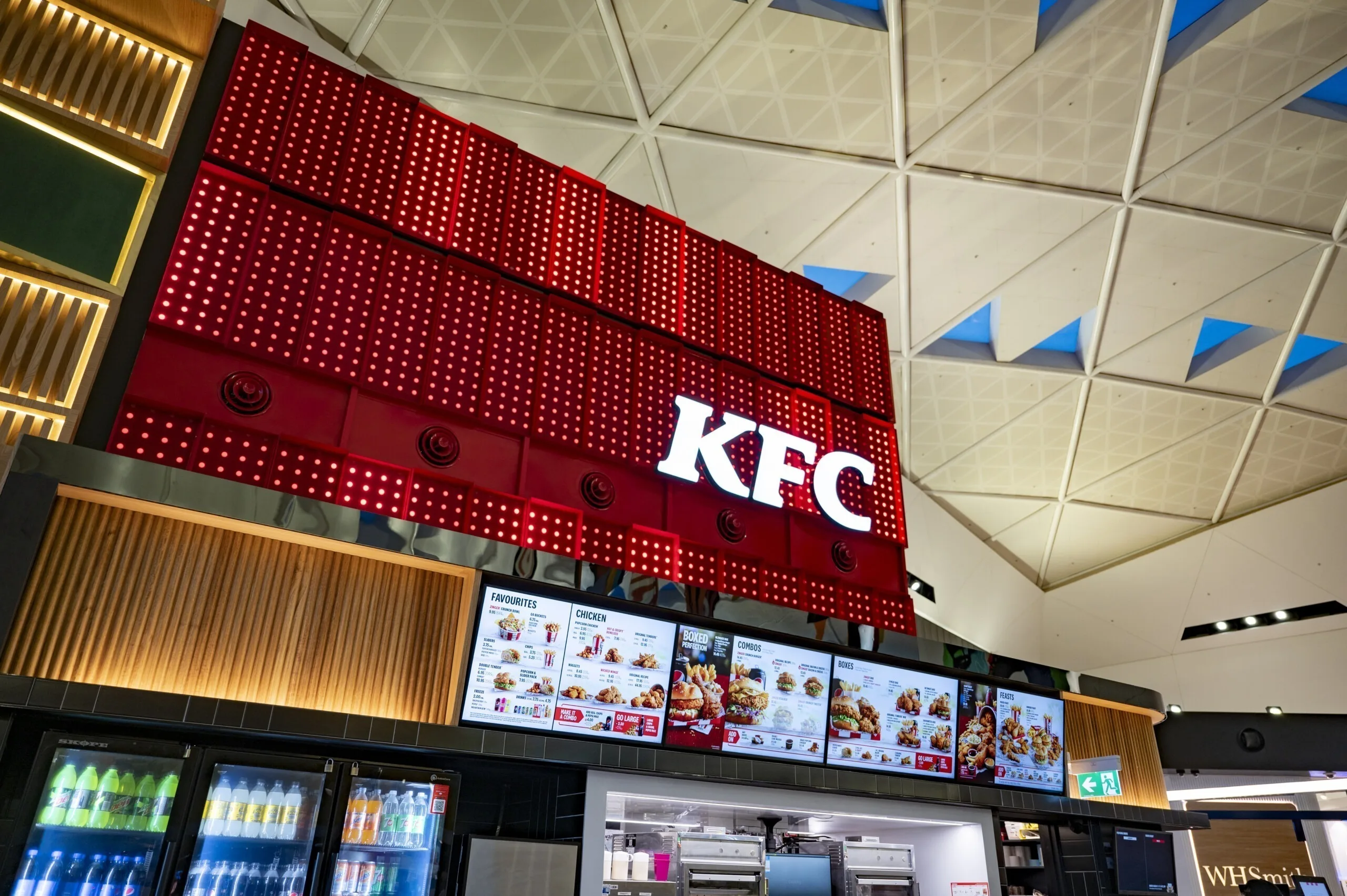 The lit box above the digital menu boards and drinks fridge, triangular skylights in the ceiling above