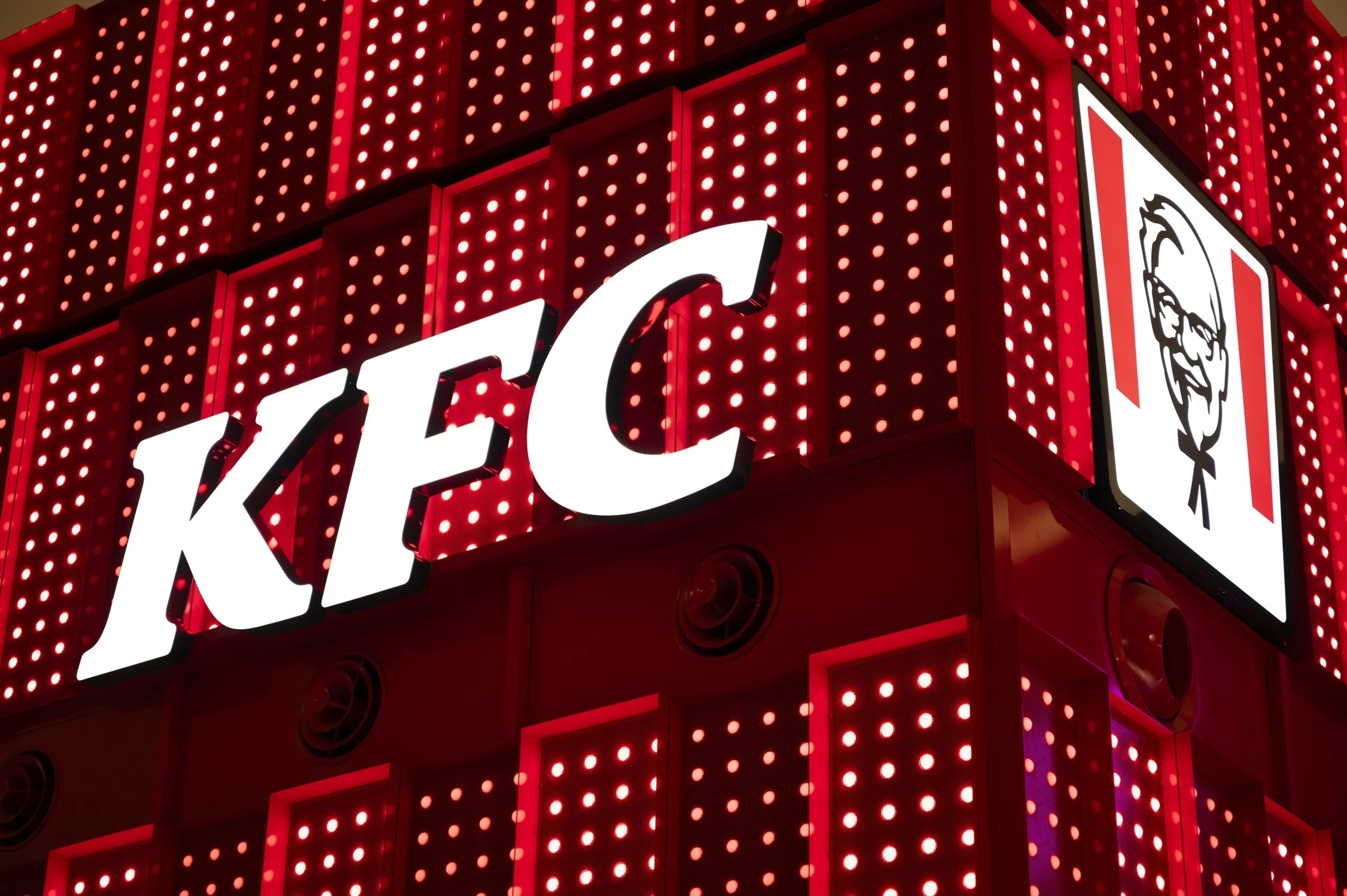 Tight corner shot with the white KFC wordmark on one face and the logo panel on the other