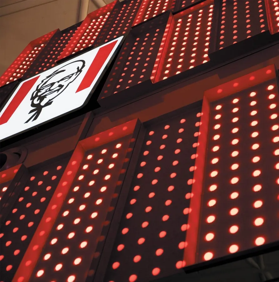 The Colonel Sanders panel at a raking angle, red panels and their white dots receding into darkness on either side