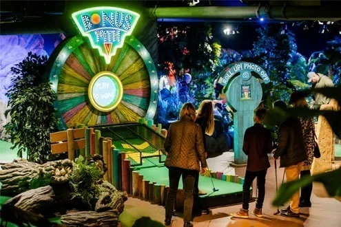 The Bonus Tree hole in full, its wheel glowing beside the Roll Up Photo Op booth at the end of the green