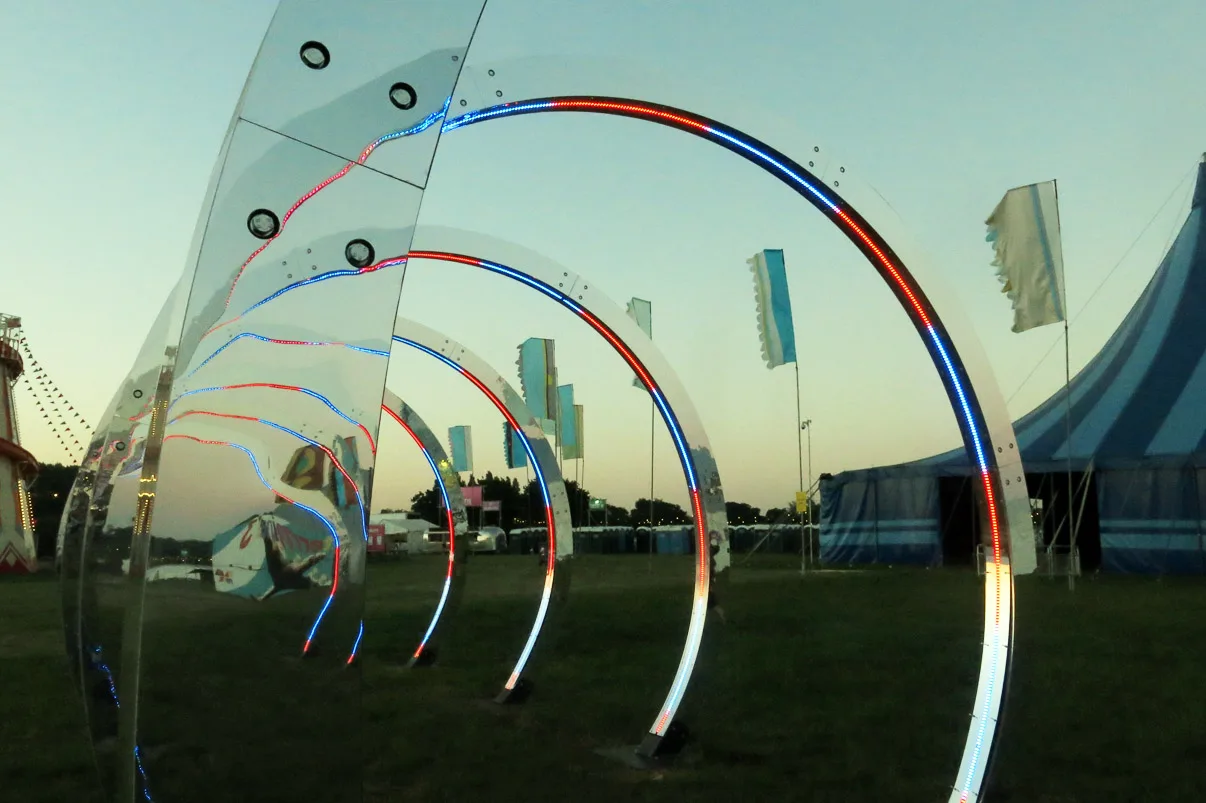 Close low angle on the hoops at sunset, red and blue pixel lines running along the mirrored rims